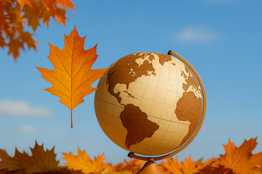 Autumn travel concept with globe and orange maple leaves against blue sky